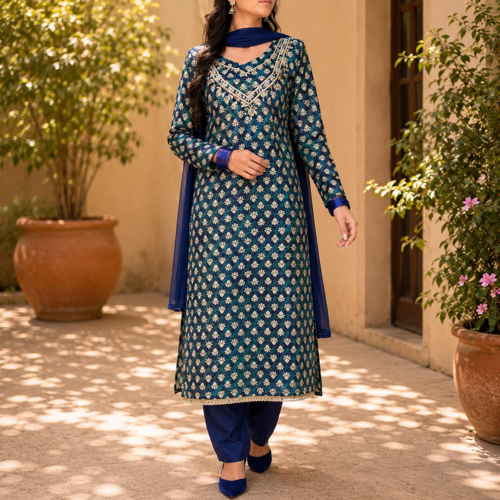 Woman wearing a traditional blue and green outfit with floral patterns in an outdoor setting.