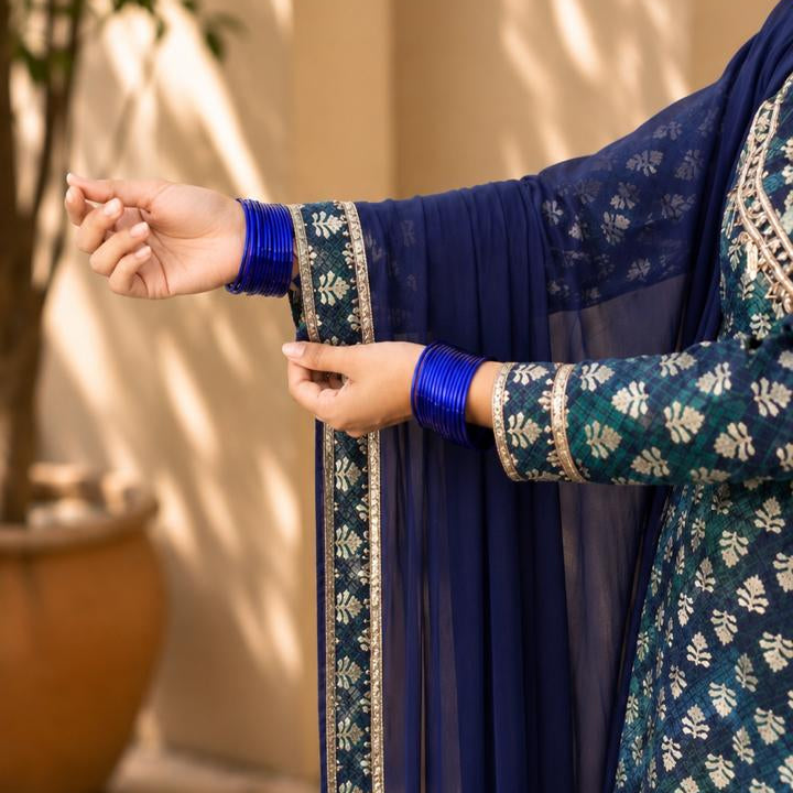 blue and green sleeve of traditional outfit with floral patterns.